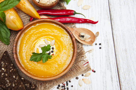 Bowl of pumpkin soup on rustic wooden backgroundの写真素材