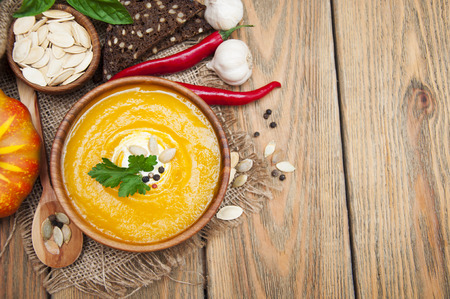 Bowl of pumpkin soup on rustic wooden backgroundの写真素材