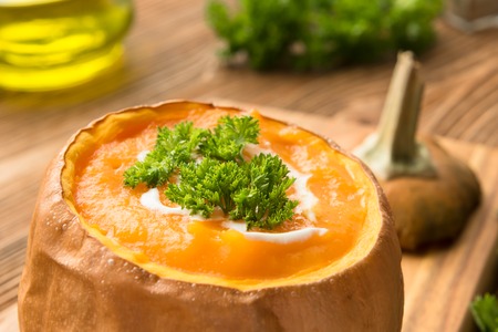 Pumpkin soup on a wooden tableの写真素材