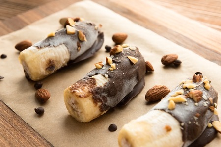 Frozen banana covered with chocolate and peanutsの写真素材