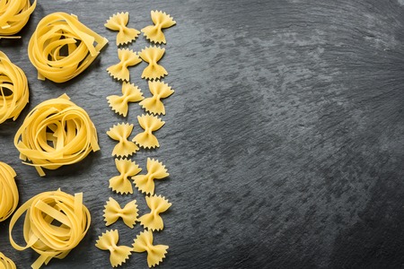 Raw italian tagliatelle and farfalle with fresh basilの写真素材