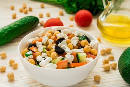Vegetarian chickpea salad with olives, feta, tomatoes, onion, garlic and a light lemon dressingの写真素材