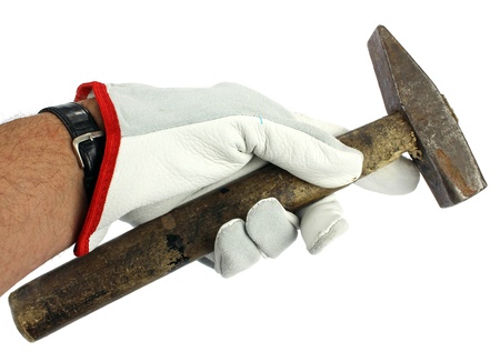 A leather gloved hand holding a hammer の写真素材
