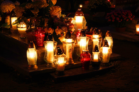 Cemetary decorated with candles for All Saints Day at night