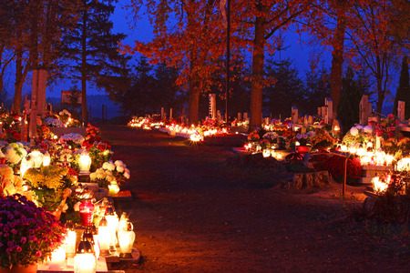 Cemetary decorated with candles for All Saints Day at nightの写真素材