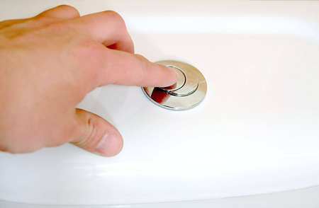 Men's hand flushing toilet.の写真素材