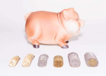 Saving coins in a piggy bank to create a saving habit.の写真素材