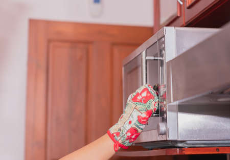 The cook is putting the food warm in the microwave.の写真素材