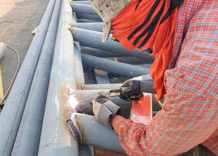 Steel pole welders for industrial roof support in middayの写真素材