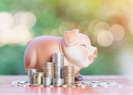Piggy bank and coin pile, investment saving concept on out of focus background.の写真素材