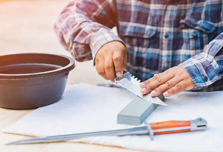 Man sharpening knives hiking to prepare for trekking.の写真素材