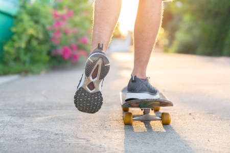 Young man play the skateboard is in front of the house instead of going to the park to prevent