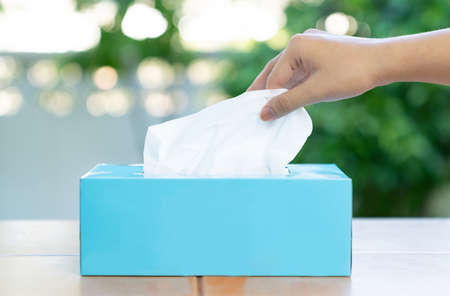 The man took the tissue from the green box on out of focus background.の写真素材