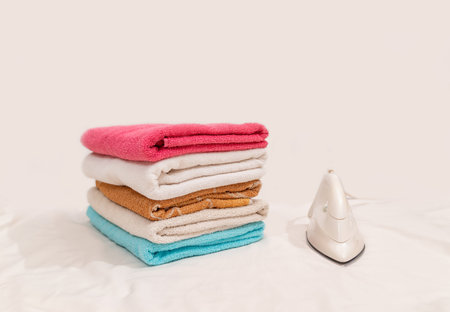 Iron and towel placed on a white background.の写真素材