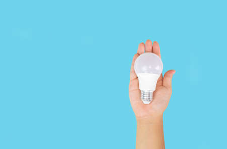 Hand holding light Bulb lamp saving energy ecology concept on isolate blue background space text.
