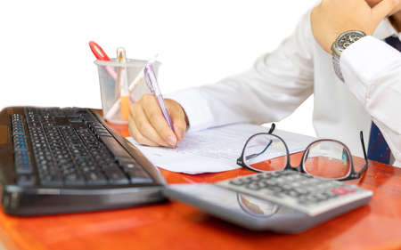 Business man working on desktop computer with business document and calculator on office tableの写真素材