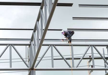 Industry worker with welding steel to build roof structure factory.