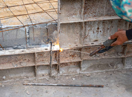 Workers welding metal formwork for concrete is pour over it in Construction site.の写真素材