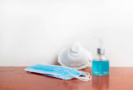 Blue face mask, N95 mask and alcohol hand gel, sanitizer spray,  protection against pollution flu and coronavirus . Health care and Covid-19 concept.の写真素材
