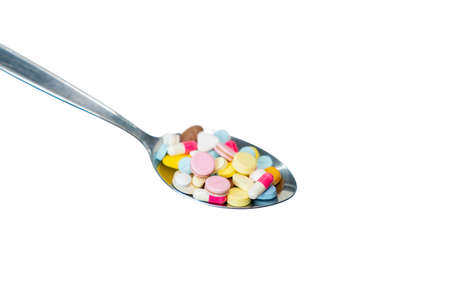Close up view of medicines in spoon isolated on white background.