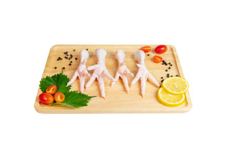 Raw Chicken feets on wooden cutting board with spices isolate white background. Top view. Copy space.の写真素材