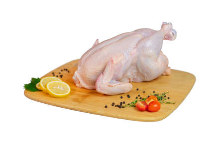 Fresh whole chicken and spices on wooden board isolate white background.の写真素材