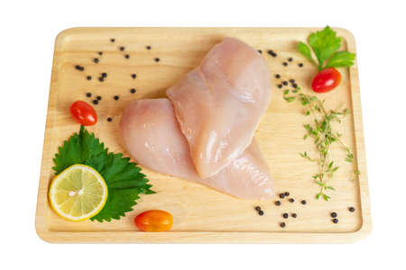 Top view of chicken breast fillet and spices on wooden cutting board isolate white background.の写真素材
