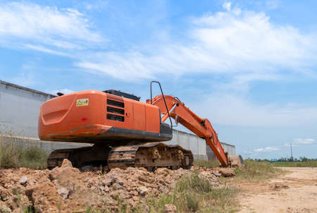 Excavator back side view digging on demolition site in factory.の写真素材