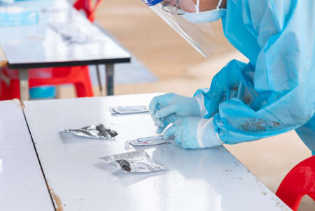 Medical personnel making a antigen rapid test kit for viral disease COVID-19 in card kit test for...