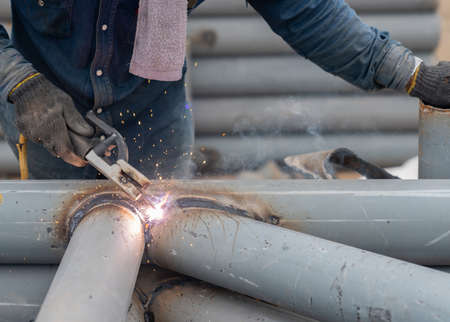 Worker welding pole structure for park roof in factory.The iron was painted with grey rust-proof paint.の写真素材