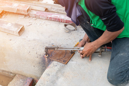 Technicians are using gas to drill holes in steel plates as a base for the structural columns.
