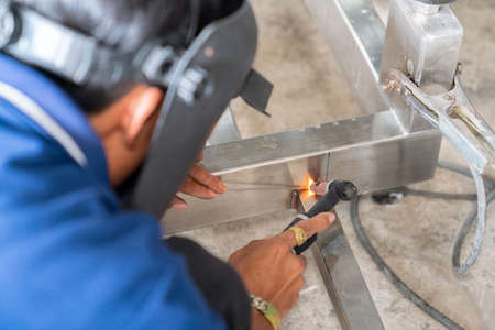 Welder wear mask use argon welding stainless steel in factory. Worker argon welding.の写真素材