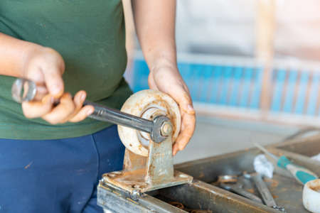 Workers remove wheelchair wheel bearings to replace them in factoryの写真素材