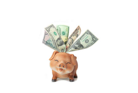 Pink piggybank stuffed with dollar bills on isolate white background.の写真素材