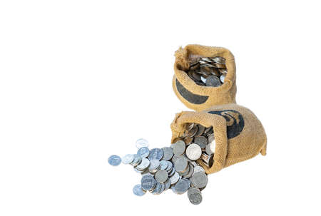 Money coin fill in old textile sack on isolated white background. Saving money concept.の写真素材