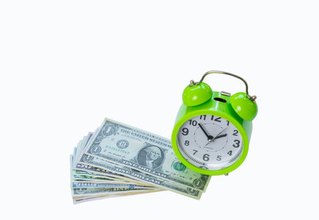 Green alarm clock sit on pile of dollar bills isolate white background. Concept of  time is money, Time to make money.の写真素材