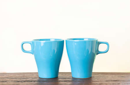 Two aqua blue cups on wood table with isolate white background. Concept about friendship,love and relationship.の写真素材