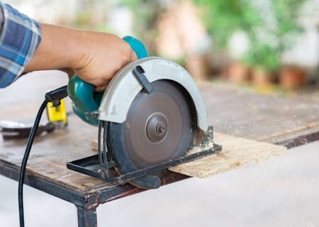 Carpenter saws a board with a circular saw in the cutting a wooden. D.I.Y conceptの写真素材