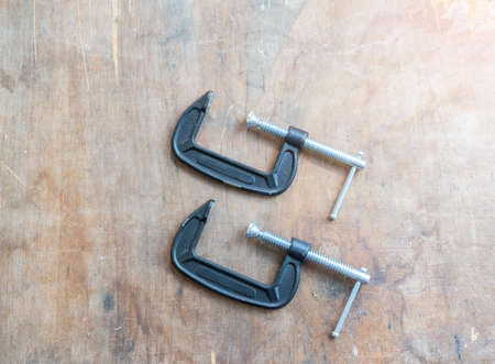 2 screw clamp paste on wood table in workshop. DIY concept.の写真素材