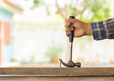 The carpenter removing rust nail from old wood to diy table in workshop.の写真素材