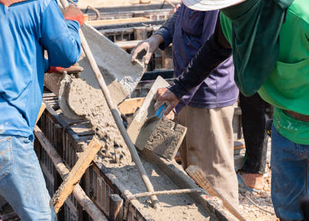 Worker pour cement on frame of beam building in construction site.の写真素材