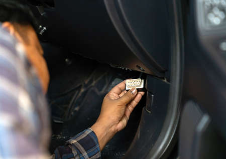 Technicial plug Diagnostic OBD II to  port under front console in car.の写真素材