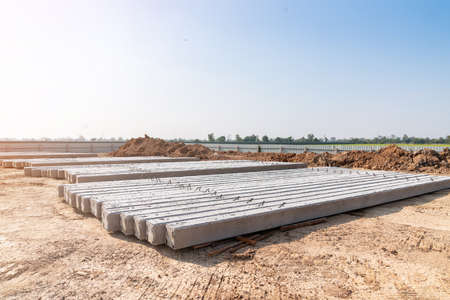 Pile of concrete piles on ground for deep foundation construction in building siteの写真素材