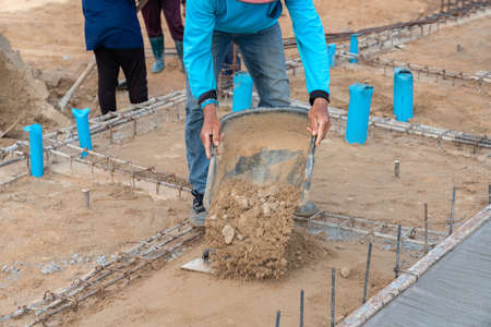 Workers fill the ground with sand to level the construction work.の写真素材