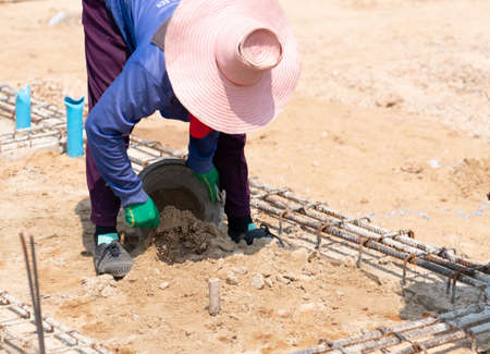 Workers use plastering trowel to dig out excess sand from the ground prepare pour cement.の写真素材