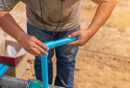 Workers wear pipes that are glued together in plumbing of building.の写真素材