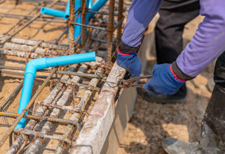 Workers tie steel wires to the ground to pour mortar in construction site.の写真素材