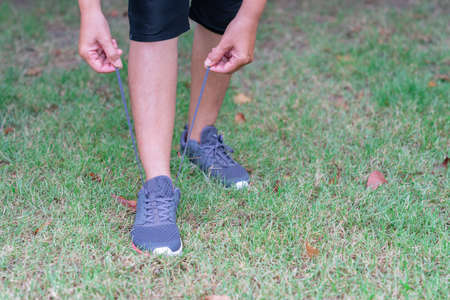 Woman tying sneakers on lawn for jogging. Healthly, jogging and run.