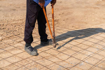 Worker cutting grating With Plier Cutter Tool At Construction Siteの写真素材