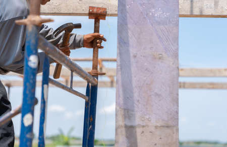 Worker Installing Scaffolding Elements for second floor formwork in building site..の写真素材